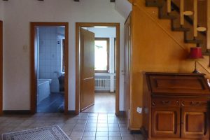 Hausflur mit Bodenfliesen und offener Treppe