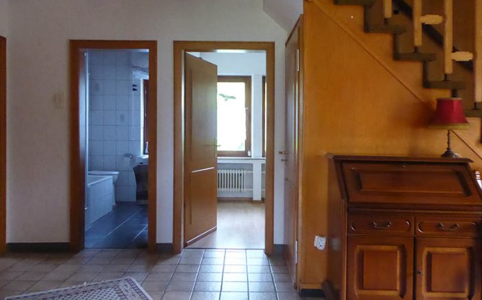 Hausflur mit Bodenfliesen und offener Treppe