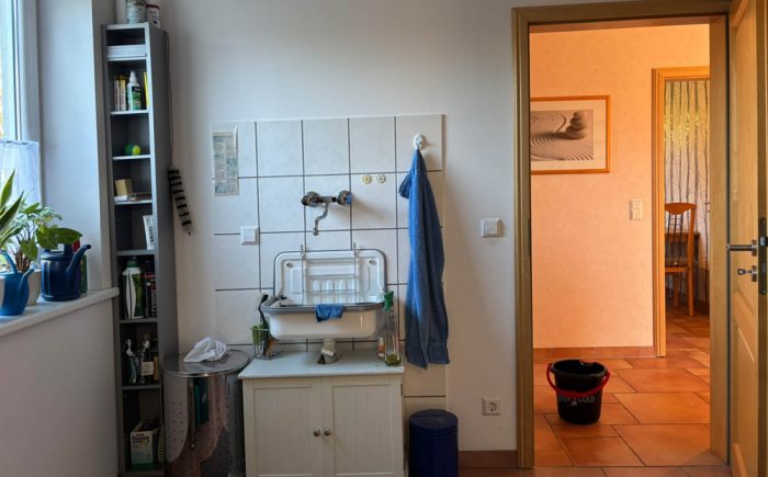 Praktischer Hauswirtschaftsraum mit Durchgang zu Garage und Garten